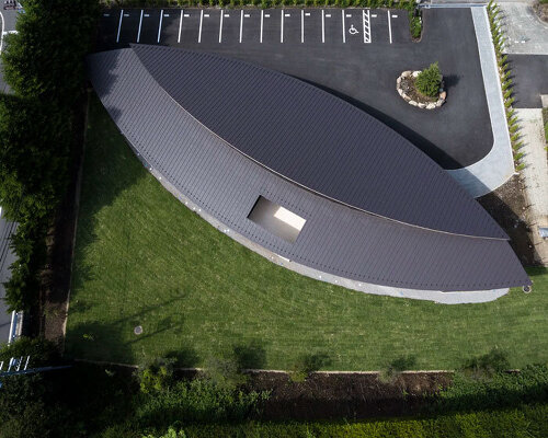 twin leaf-shaped roofs unfold atop nursery school by NIKKEN SEKKEI in japan