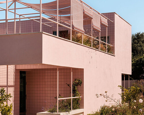 atelier RUA’s light pink house contrasts with surrounding greenery in portugal